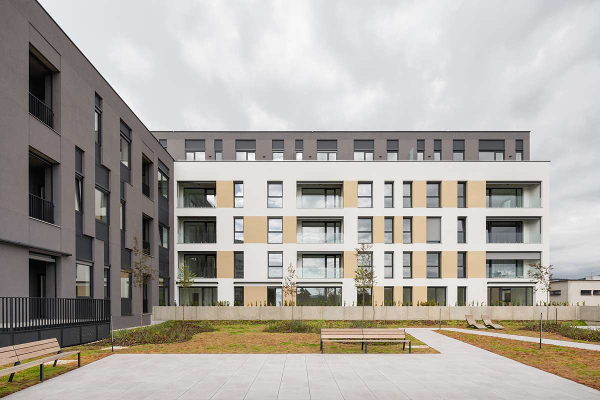 Fasáda objektu sa vyznačuje pravidelným rastrom okenných otvorov a farebným kontrastom medzi jednotlivými krídlami.