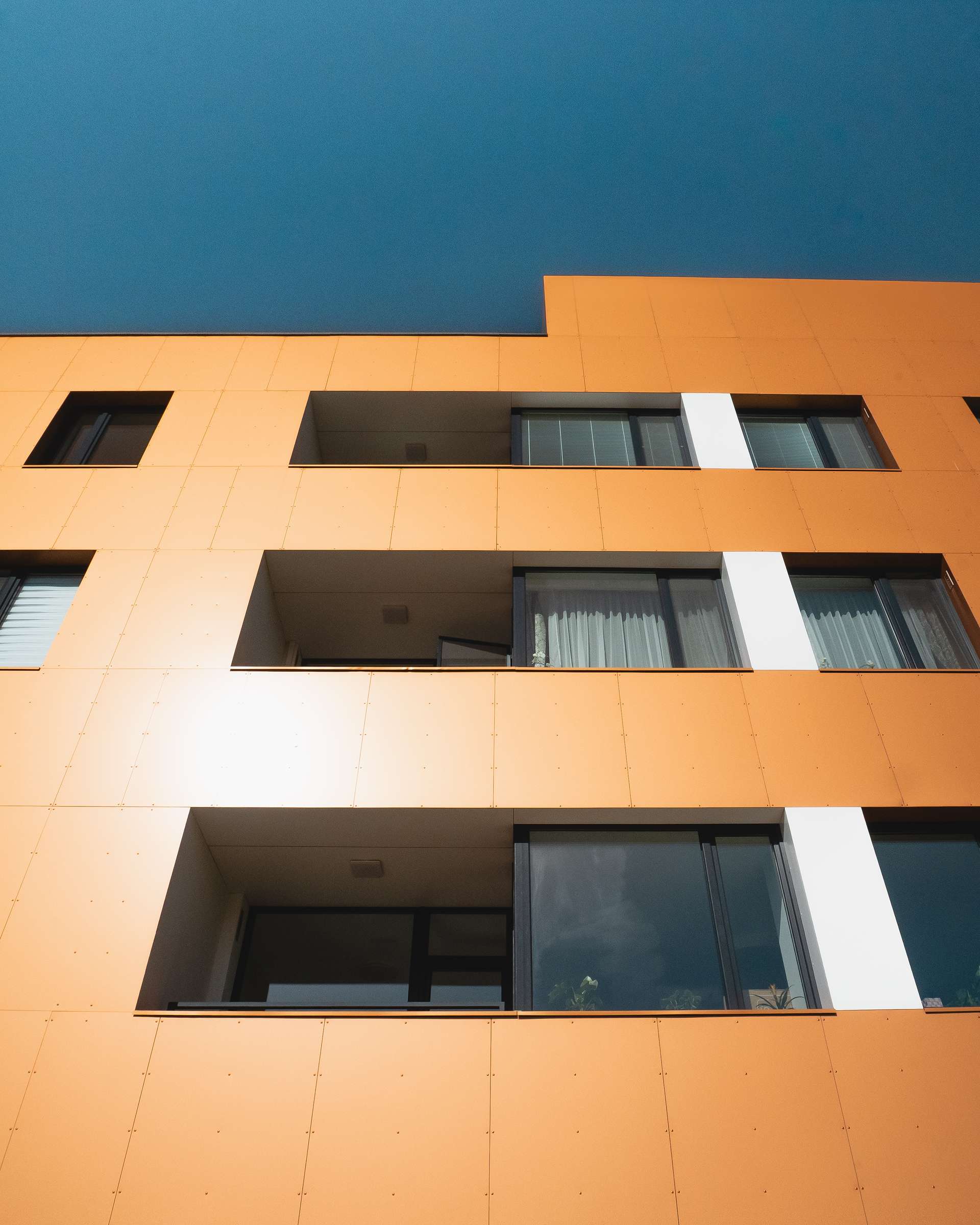 Druhé až štvrté nadzemné podlažie je charakteristické pravidelným rastrom okenných otvorov a lodžií so šikmým zapustením.