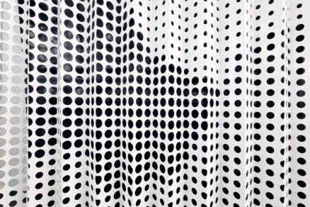 Detailný pohľad na perforovaný kovový panel s pravidelným kruhovým vzorom