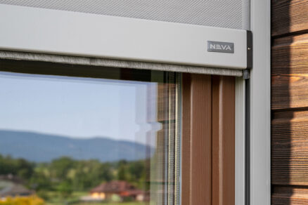 Detail screenovej rolety s bielym boxom a výhľadom na prírodu