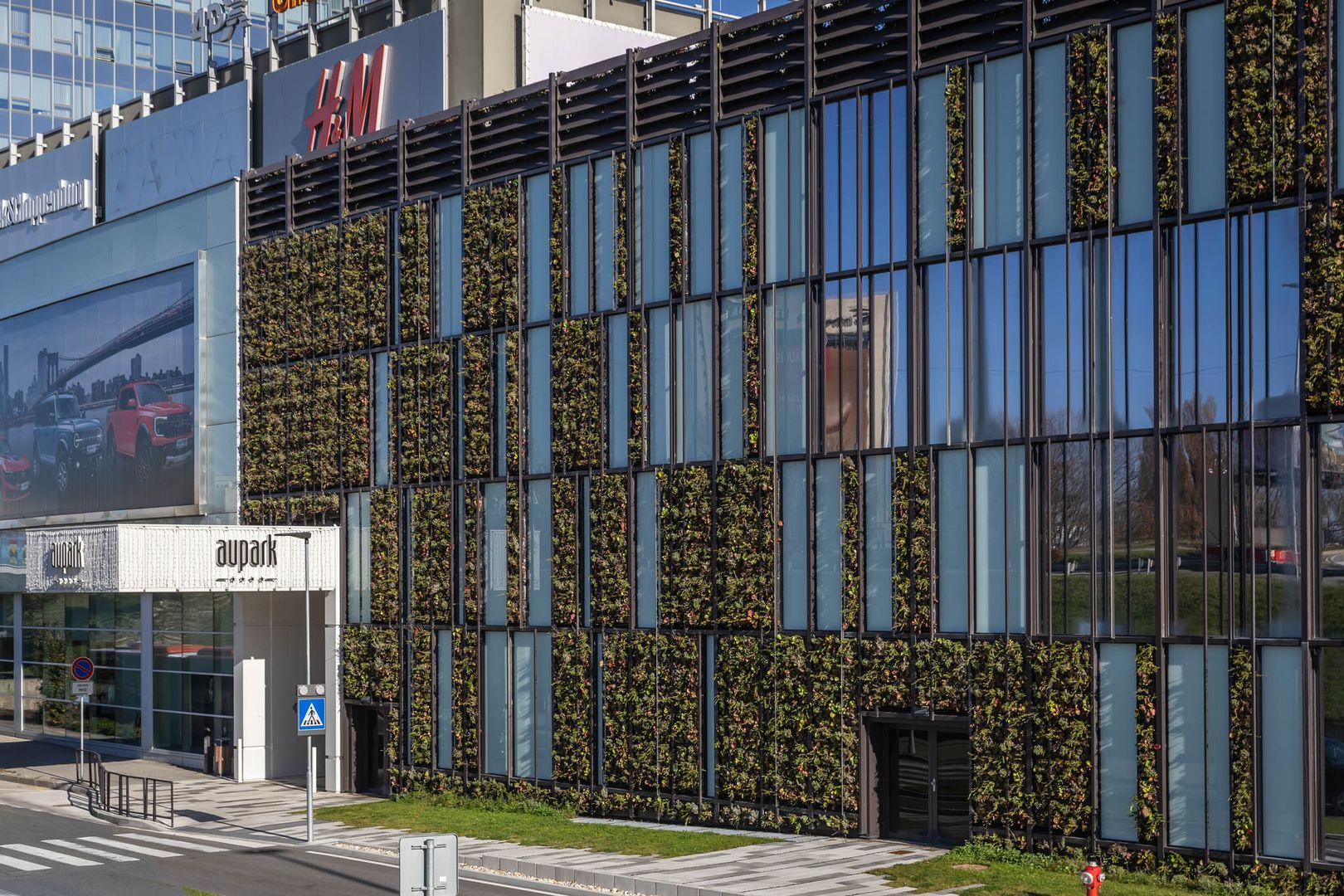 Zelená fasáda je skutočne atypická – svojím zaoblením rohu aj kombináciou sklenených panelov so zeleňou.