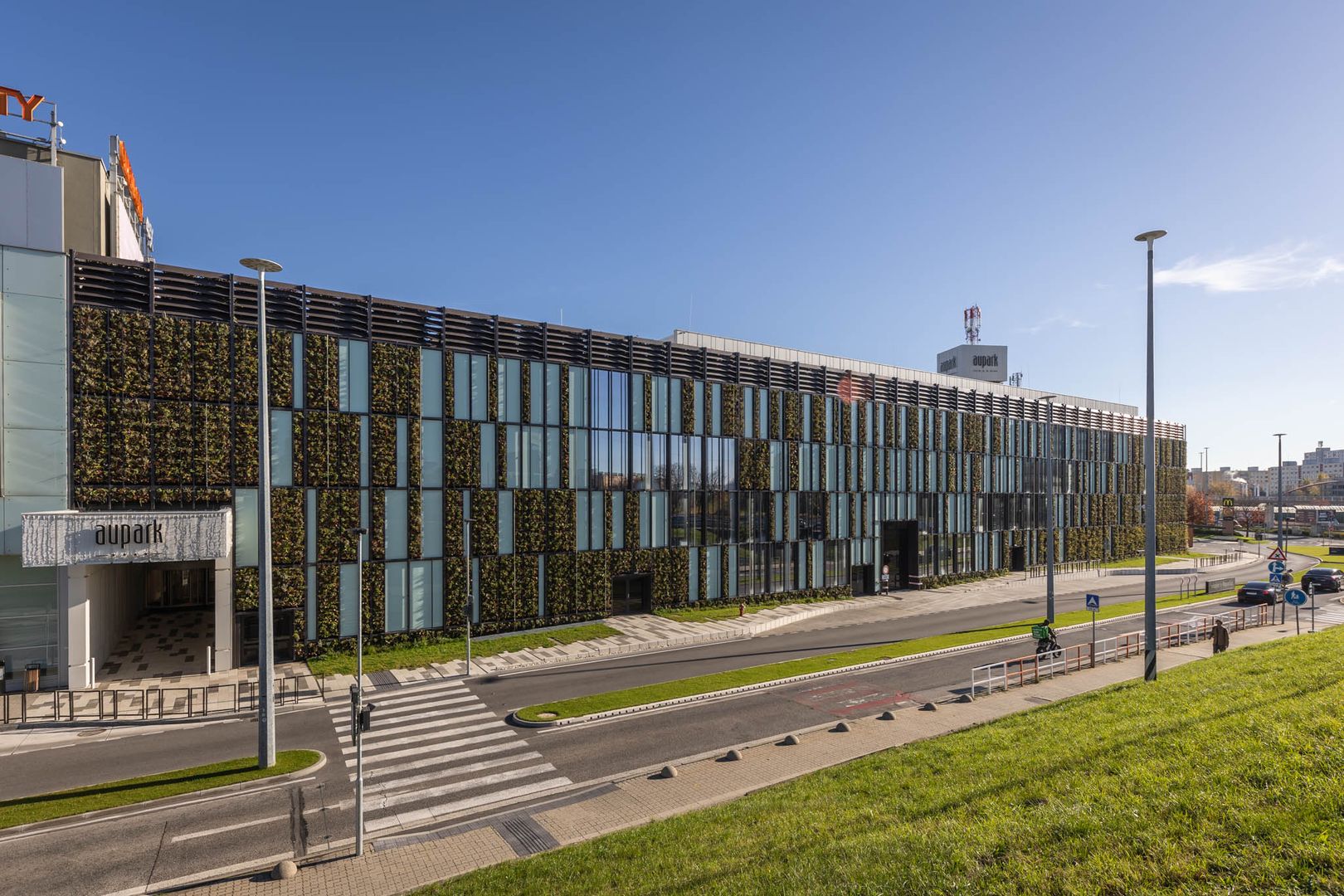 Zelená fasáda je skutočne atypická – svojím zaoblením rohu aj kombináciou sklenených panelov so zeleňou.