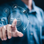 Muž ovláda digitálne rozhranie s ikonami facility managementu, udržateľnosti, AI a bezpečnosti.