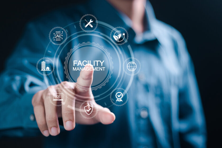 Muž ovláda digitálne rozhranie s ikonami facility managementu, udržateľnosti, AI a bezpečnosti.