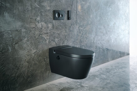 Čierna sprchovacia toaleta s diaľkovým ovládaním v modernej kúpeľni s betónovým obkladom