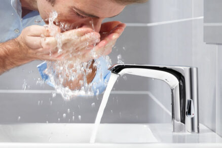 Používateľ si oplachuje tvár pri senzorovej batérii s laminárnym prúdom