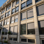 Screenové rolety na oknách administratívnej budovy v mestskom prostredí