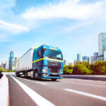 Nákladné vozidlo na diaľnici v meste – logistika pre stavebníctvo a priemysel