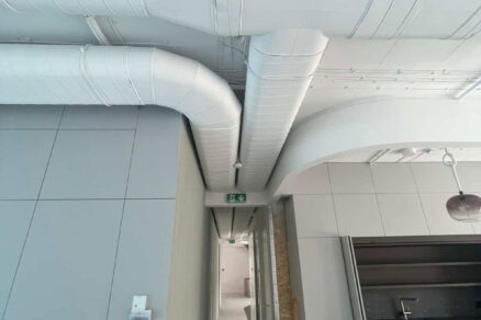 Vzduchotechnické potrubie vedené pod stropom v interiéri budovy