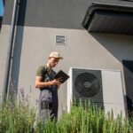 Technik kontroluje tepelné čerpadlo pri rodinnom dome