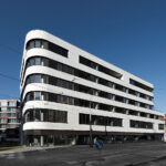 Bytový dom s oblými líniami a horizontálnymi pásovými oknami