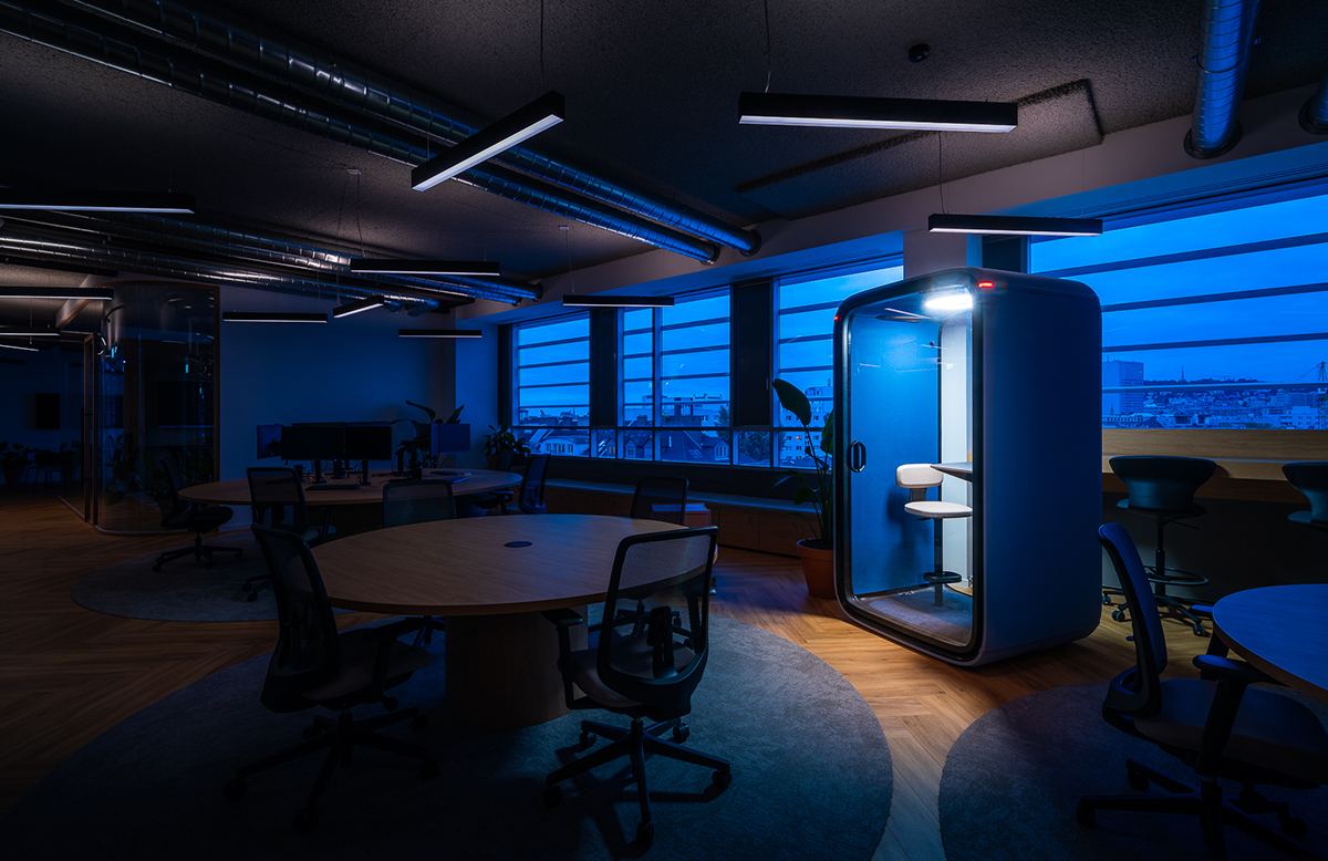 Moderný kancelársky interiér s akustickou telefonickou kabínou a ambientným osvetlením