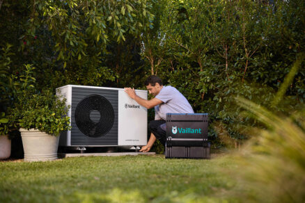 servis technik kontroluje vonkajšiu jednotku tepelného čerpadla v záhrade