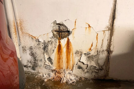 Aktívny priesak vody v stene garáže s výkvetmi solí a poškodenou omietkou