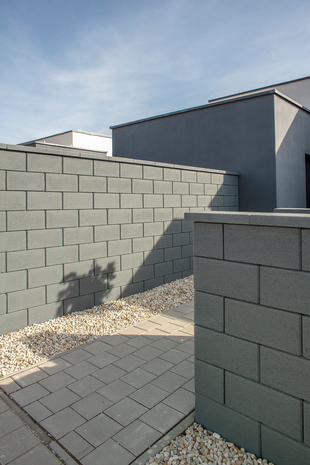 : Hladké betónové tvárnice v pravidelnom rastri pôsobia čisto a nadčasovo, vhodné k modernej architektúre.