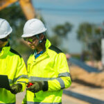 stavební inžinieri kontrolujú projekt na stavbe pomocou notebooku