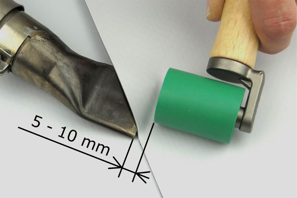 04. Pritláčanie spoja
Približne 5 až 10 mm pred koncom dýzy sa prechádza po spoji prítlačným valčekom. Tlak na valček by sa mal vyvíjať predovšetkým pri pohybe von zo zvaru. Pri neprimeranom tlaku v opačnom smere sa môže fólia neželane zvlniť. 