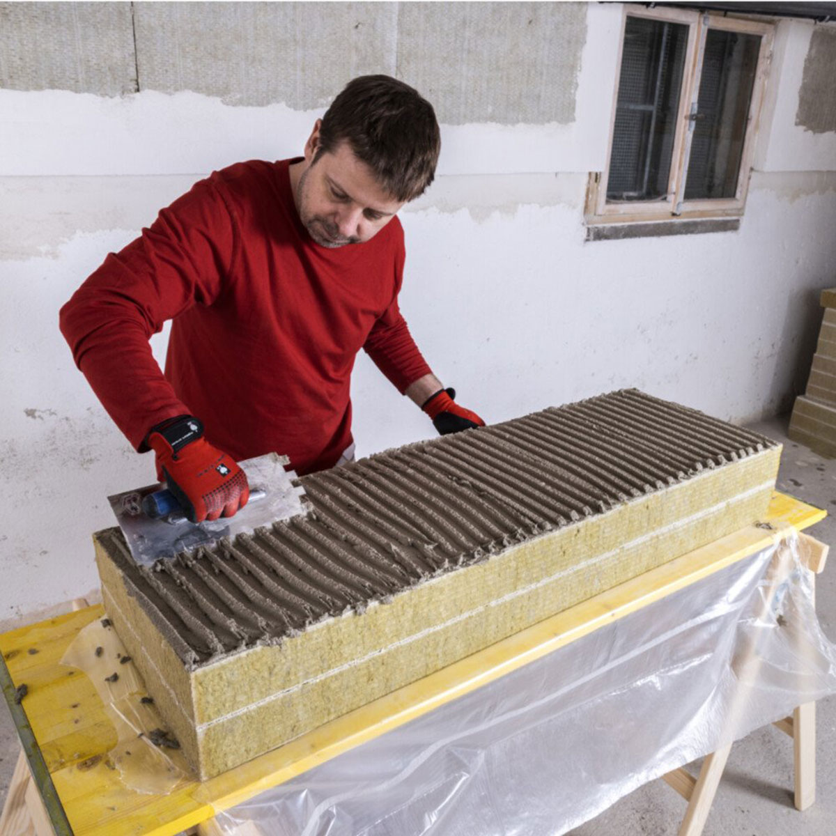09. Roztretie lepiacej malty
Čerstvo nanesená lepiaca stierka sa rovnomerne rozotrie pomocou zubového hladidla po celej ploche tepelnoizolačnej dosky. 
