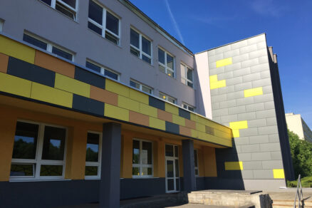 Fasádny obklad školy v kombinácii sivej a žltej farby