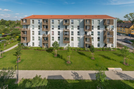 Modulárny bytový dom s prefabrikovanými balkónmi a modernou fasádou.
