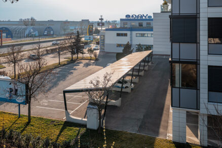 Solárny carport na firemnom parkovisku pri administratívnej budove v Bratislave umožňuje výrobu elektriny priamo v mieste spotreby a zároveň chráni zaparkované vozidlá pred poveternostnými vplyvmi.