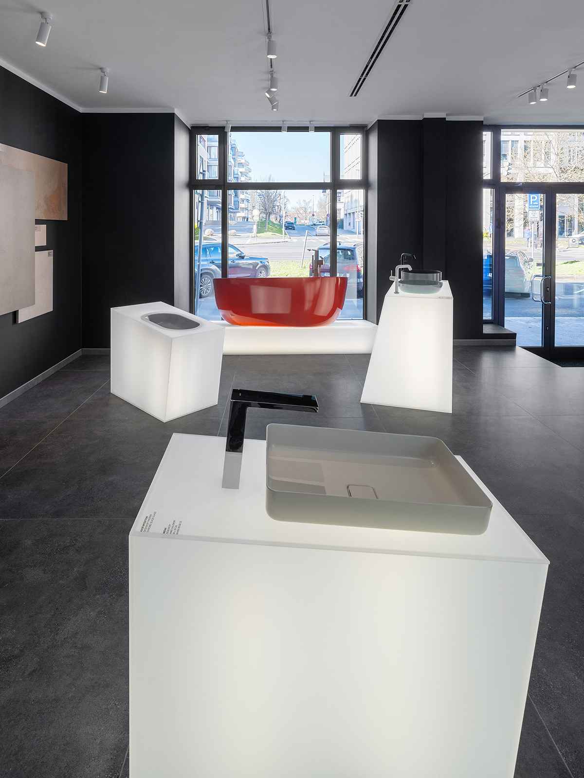 showroom kúpeľní HUB IN BATH s vystavenými umývadlami, batériami a červenou voľne stojacou vaňou
