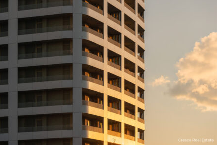 Detail fasády modernej výškovej budovy s balkónmi v rezidenčnom developmente.