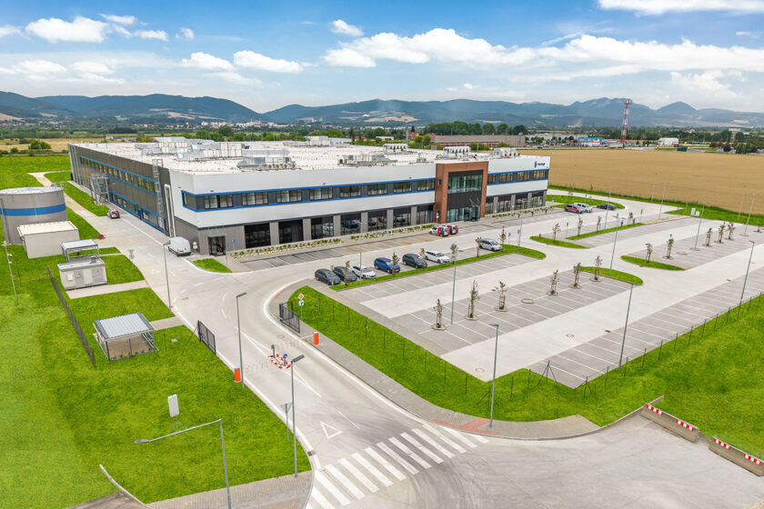 Letecký pohľad na nový výrobný areál Newbuild Neways v Novej Dubnici s dvojpodlažnou výrobnou halou, administratívnou časťou, parkoviskami a logistickou infraštruktúrou.