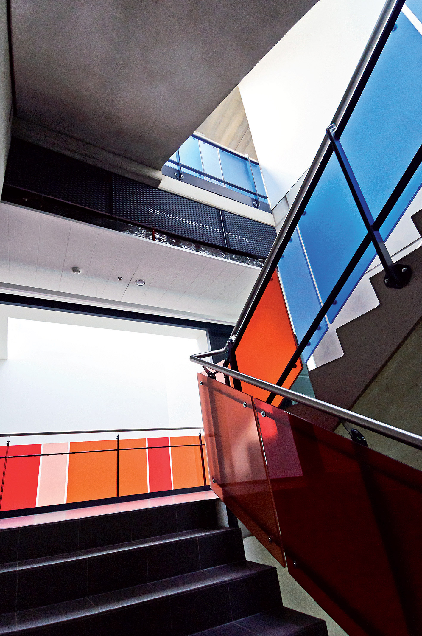 Pohľadový betón a farebné akcenty v korporátnych farbách interiéru svedčia.
