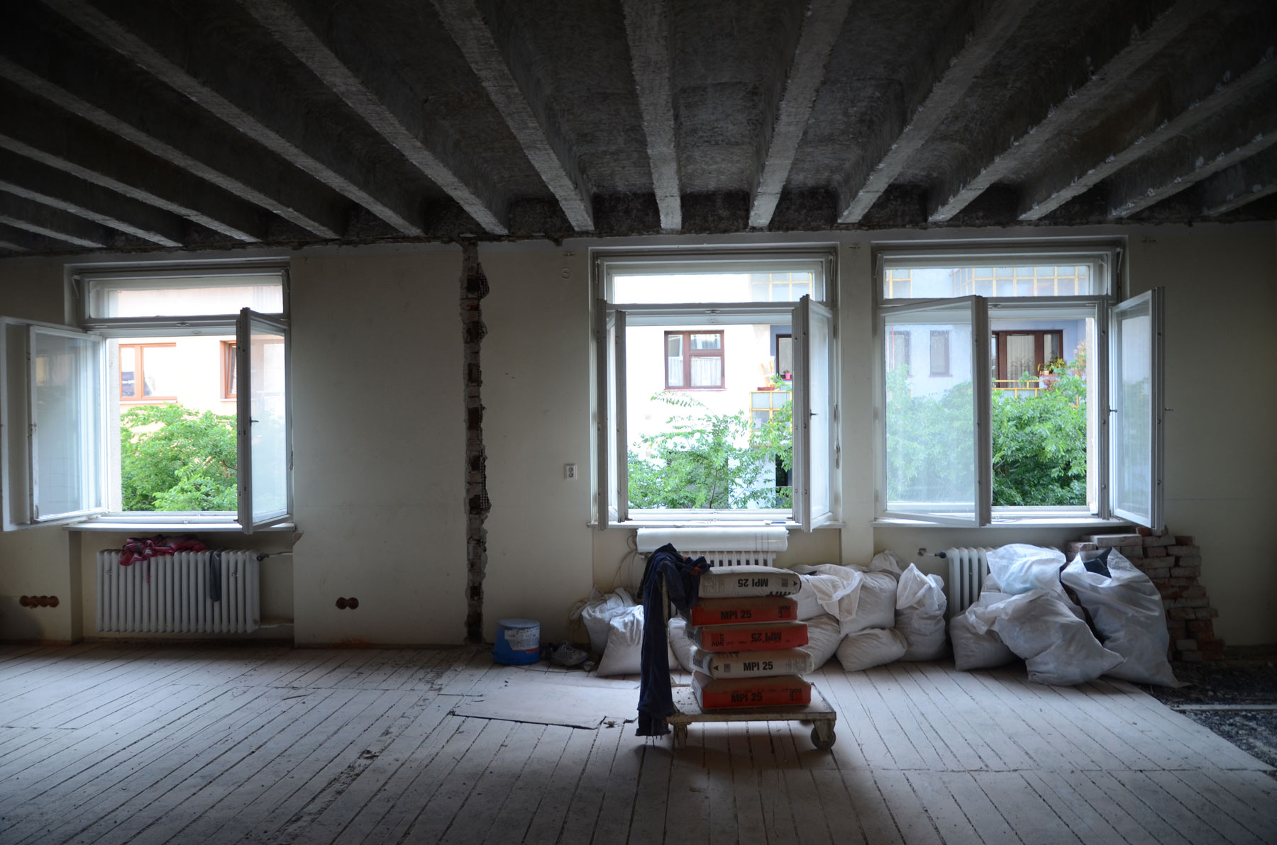 Obr. 5, 6 Zmena dispozície bytu začala „od podlahy“. Vyčistili sa priestory, aby sa mohol zrealizovať zámer, a priznali sa stropné trámy.