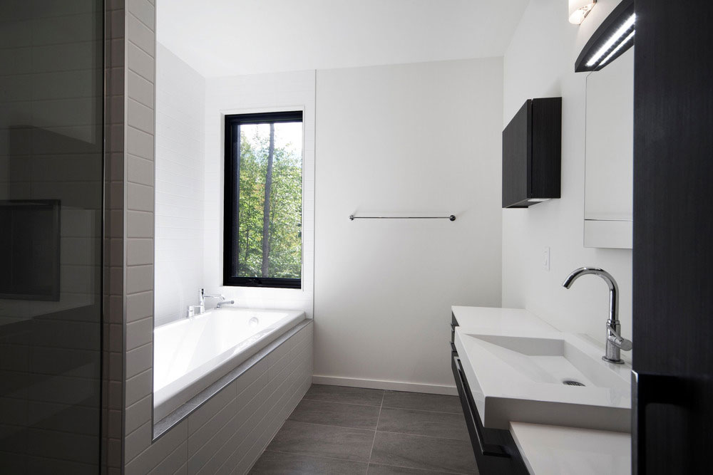 Monochromatická kúpeľňa pôsobí minimalisticky čistým dojmom. Interiér sa spolieha na krásu okolitej prírody, ktorú vhodne dopĺňa nekomplikovaným dizajnom.
