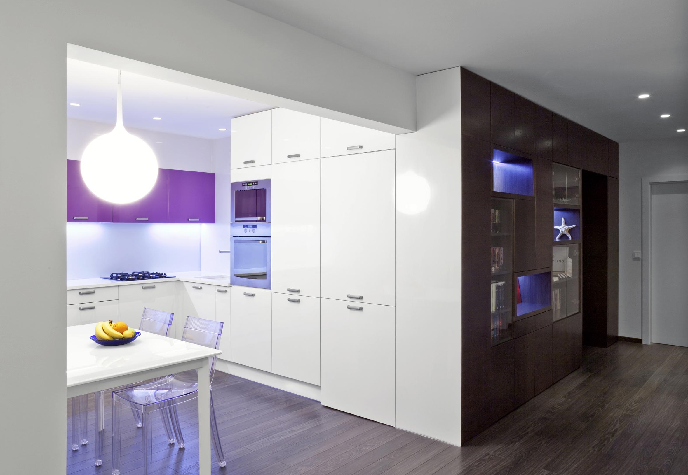 Dominantná nábytková stena, ktorá vychádza z presne definovanej požiadavky na rozsah a formu úložných priestorov, sa tiahne celým otvoreným priestorom od spálne až po koniec kuchyne.