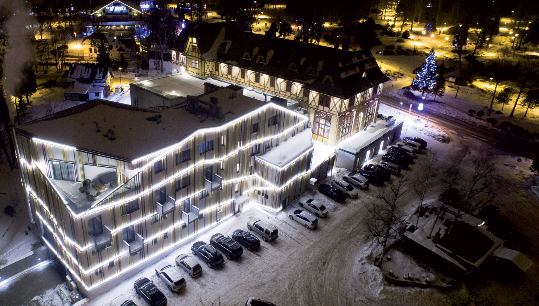 Historická a moderná časť Hotela Lomnica vo večernej atmosfére