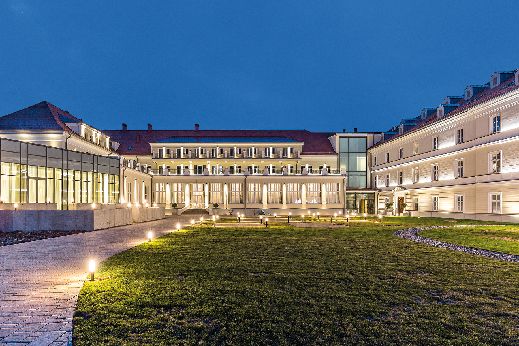 Hotel Royal Palace vo večernom osvetlení zo strany kúpeľného parku.