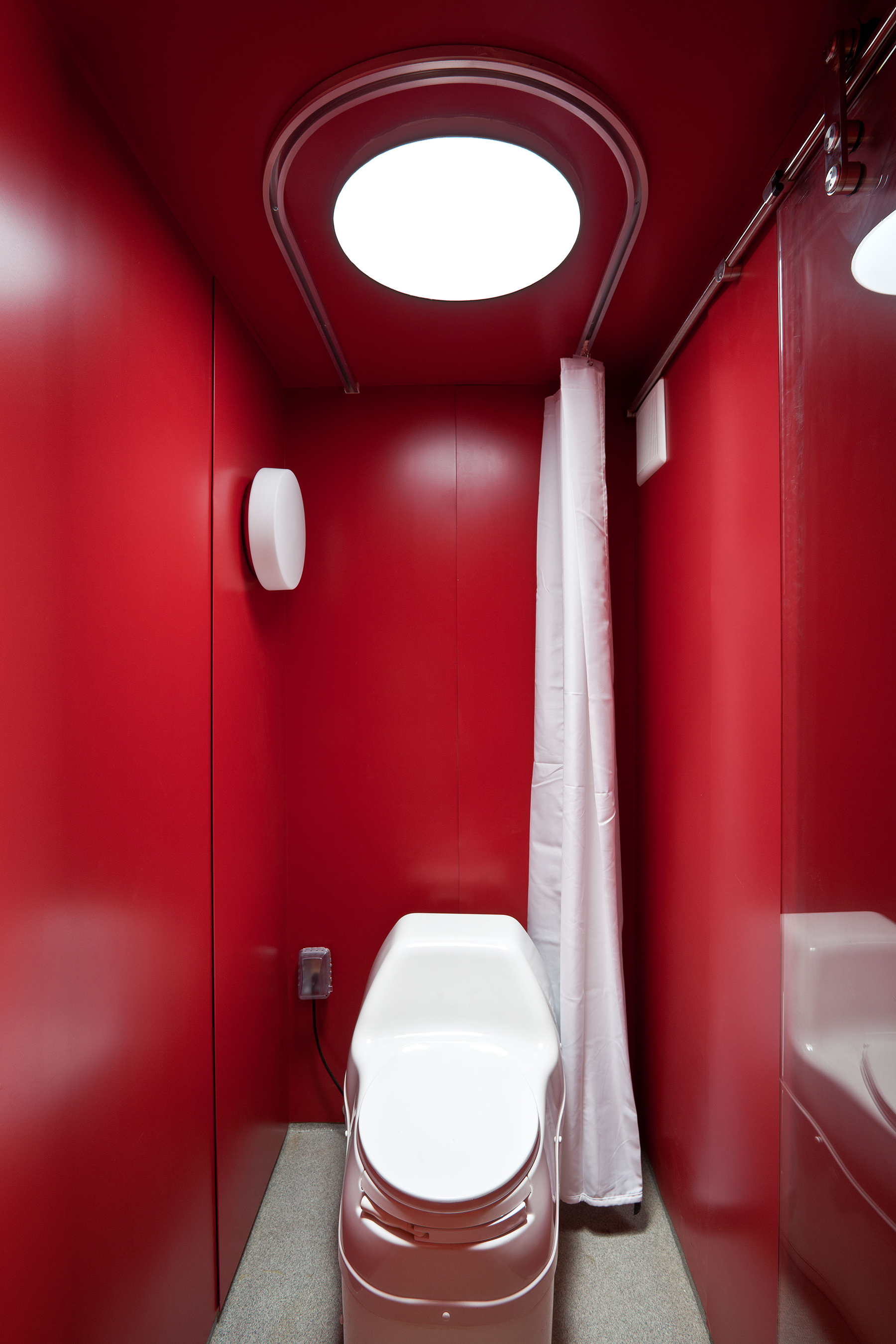 Kúpeľňa, pokrytá červeným plechom, je vybavená kompostovacou toaletou.