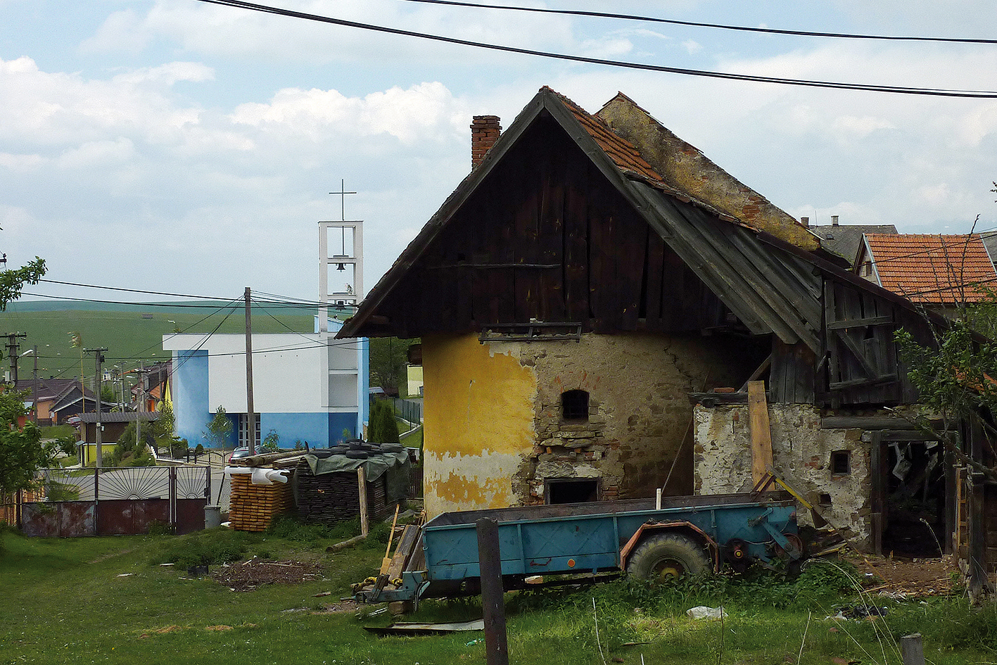 V popredí dnes neexistujúci kostolík vo Vlkovej-Levkovciach, vybudovaný na základoch románskeho kostola v 18. storočí. V pozadí nový kostol.