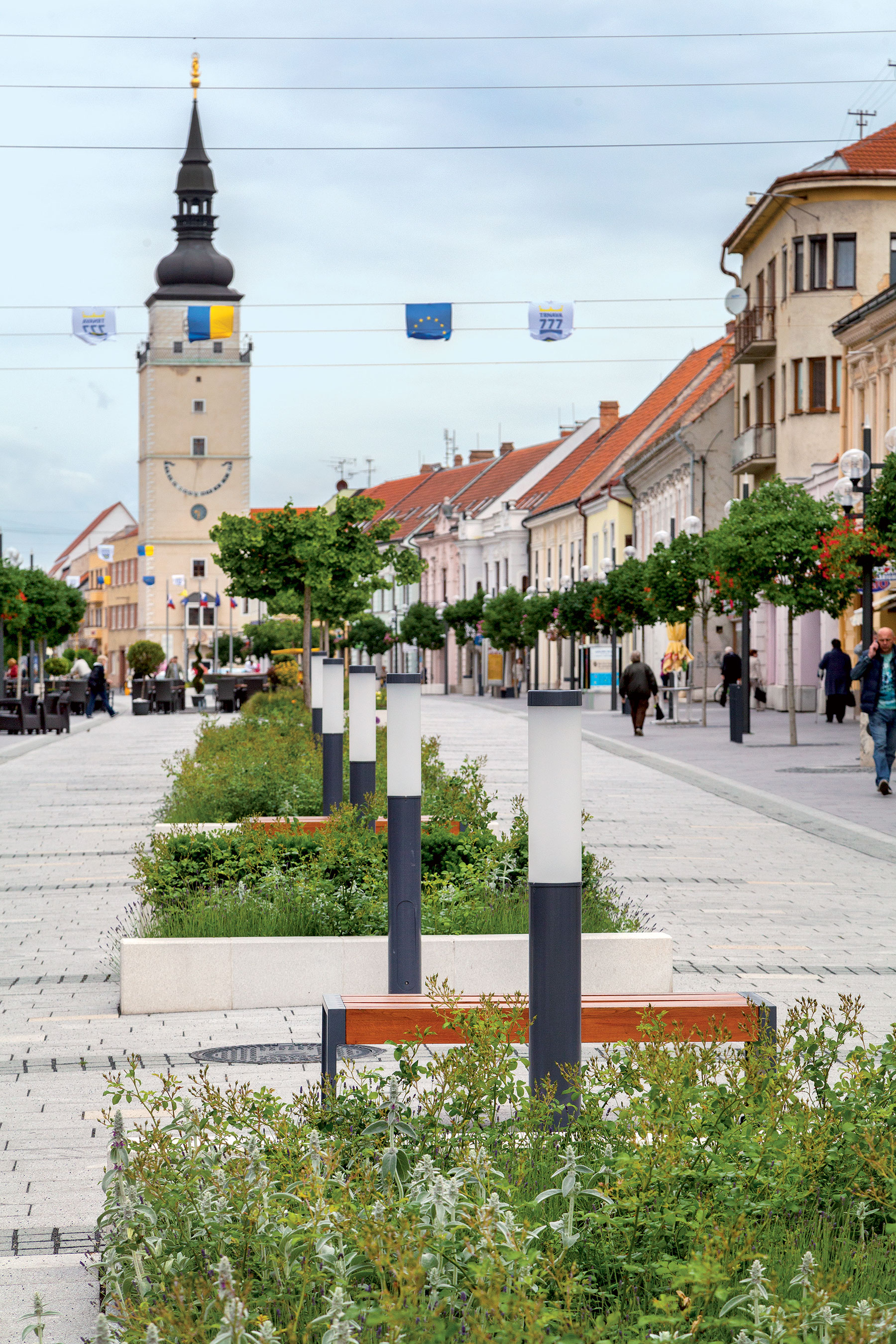  Charakteristickým vizuálnym znakom pešej zóny je mestská veža. Primeraná výška zelene nenarúša dôležité priehľady.