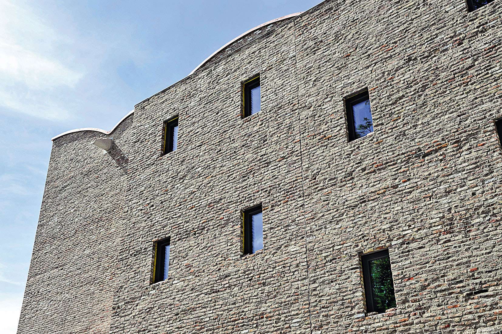 Fasáda je archaicky jednoduchá s malými okennými otvormi, ktoré vyhovujú vystaveným tlačovinám citlivým na svetlo. Vonkajšie steny s masívnym zateplením sa zároveň podieľajú na energetickej účinnosti budovy.