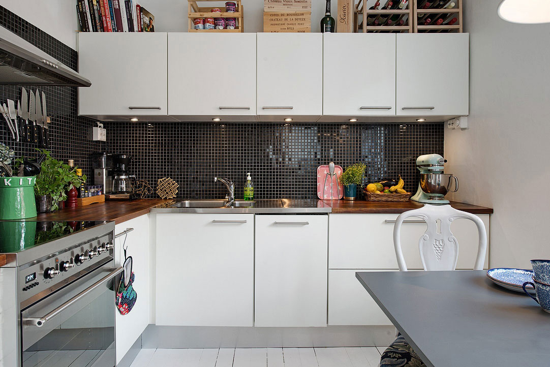 Veľkorysý priestor umožňuje realizovať sa v kuchyni viacerým kuchárom súčasne. Kontrast bielej linky a čiernej mozaikovej zásteny krásne vertikálne oddeľuje jednotlivé roviny priestoru.