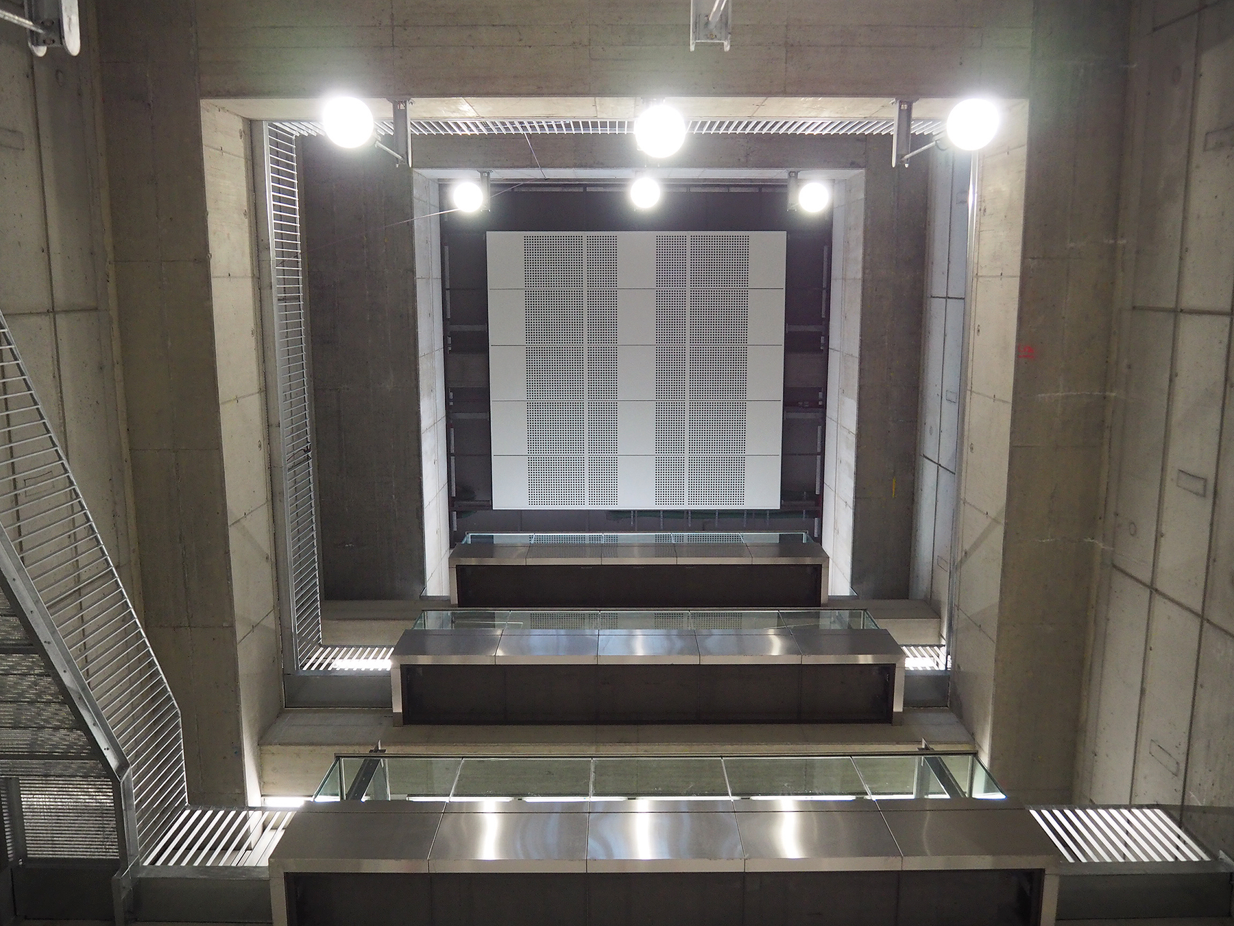 Monumentálna výška priestoru vstupnej šachty pod vestibulom stanice Favoritenstrasse s „balkónmi“ schodiska a trojicou osobných výťahov