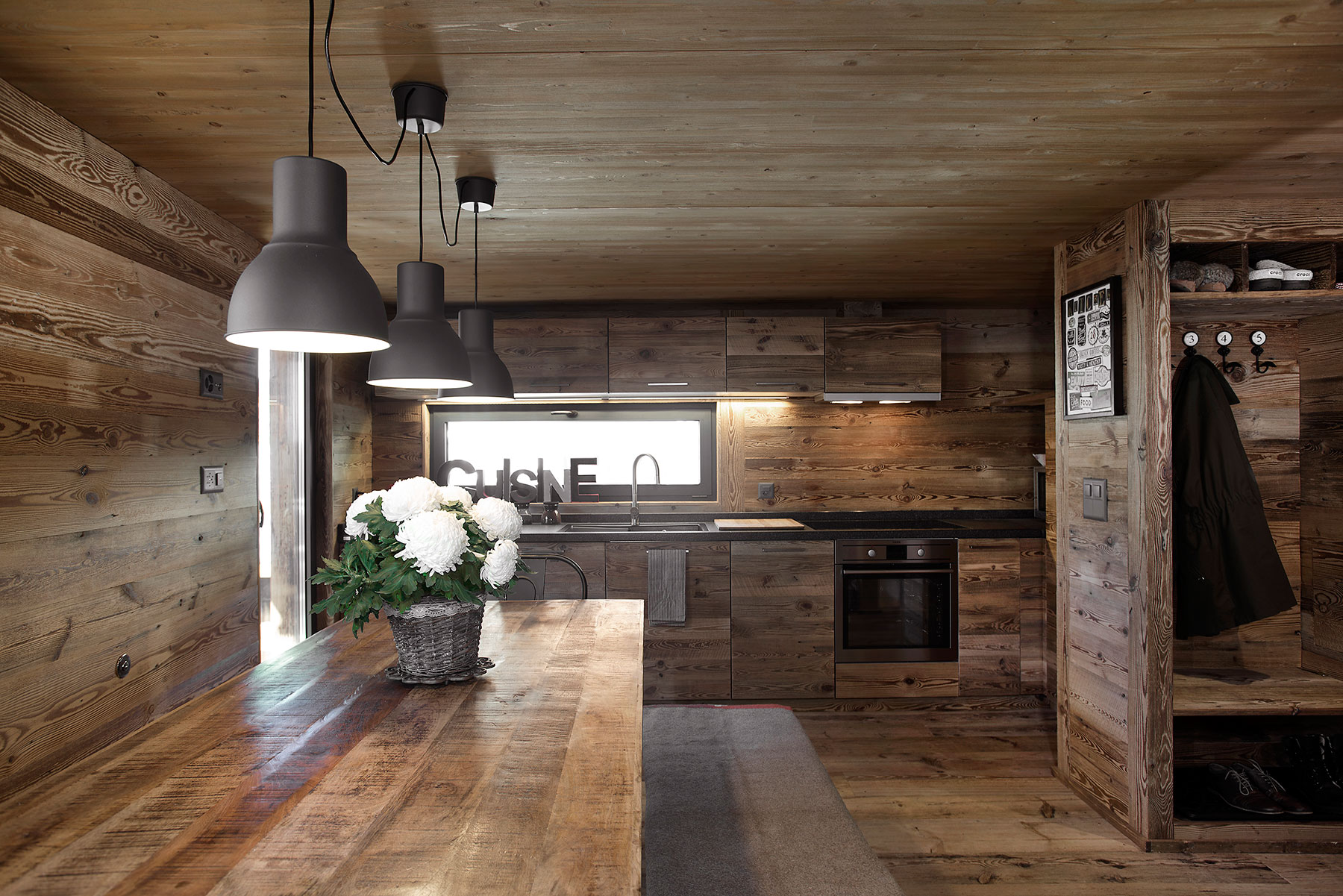 Interiéru tak ako exteriéru dominuje drevo. Pôsobí veľmi teplo a zjednocujúco. Interiér kuchyne s jedálňou.