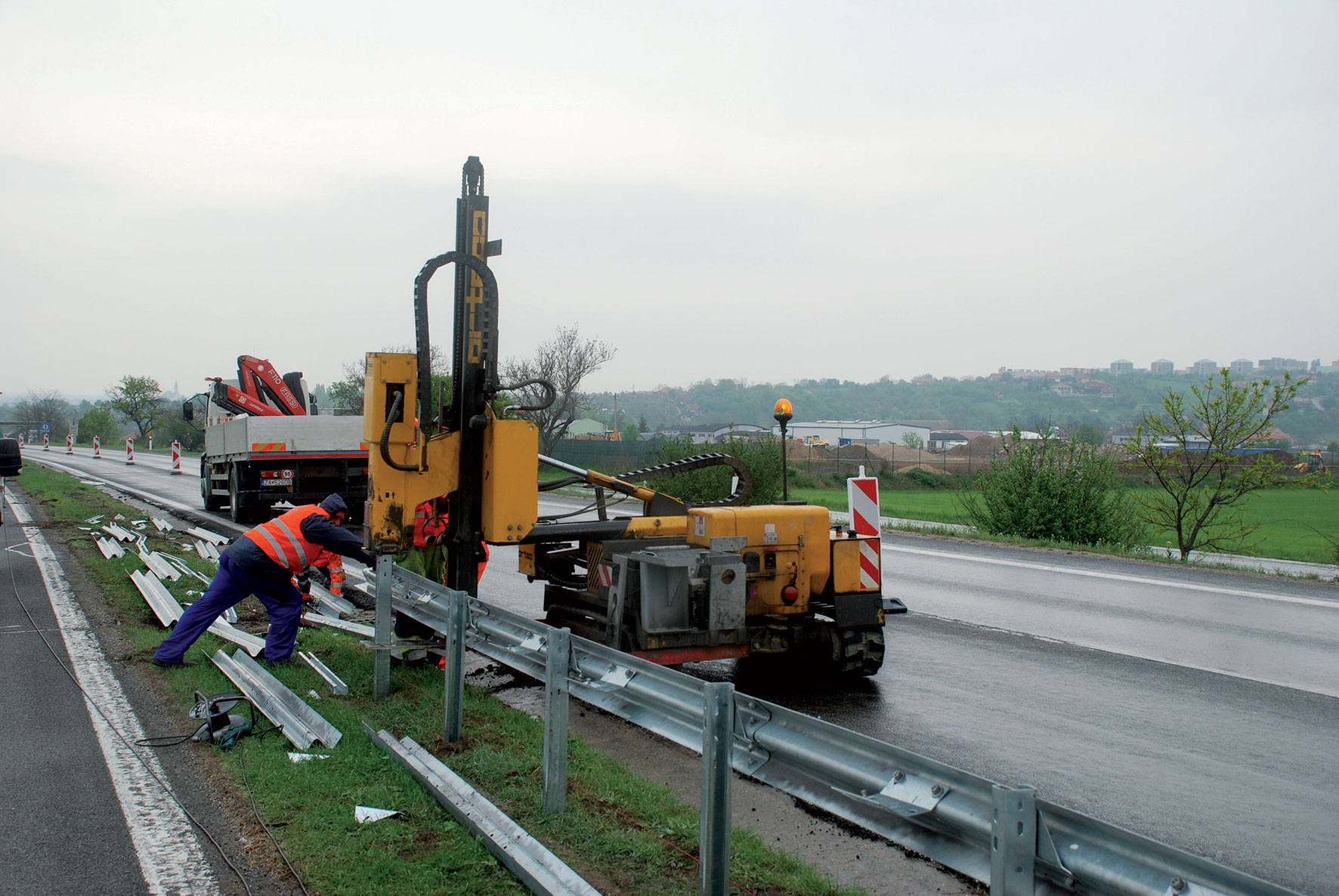 Práce na osádzaní stĺpikov zvodidla baranením