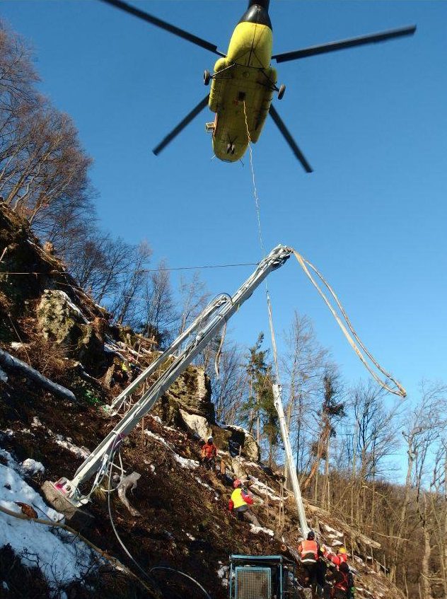 Obr. 2: Osadenie stĺpov bariéry MACCAFERRI RMC300/A výšky 5m za pomoci leteckej techniky