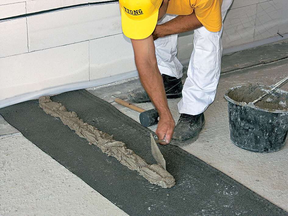 06 | Založenie prvého radu Pod budúcu nenosnú priečku sa rozprestrie hydroizolačný pás, napríklad asfaltovaná lepenka. Prvý rad sa zakladá do vápenno--cementového lôžka s hrúbkou minimálne 20 mm.